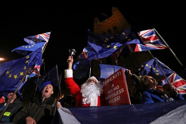 An anti-Brexit demonstrator dressed as Santa protests outside the British parliament. Brexit has made the transport of goods between the UK and the EU more complicated. 