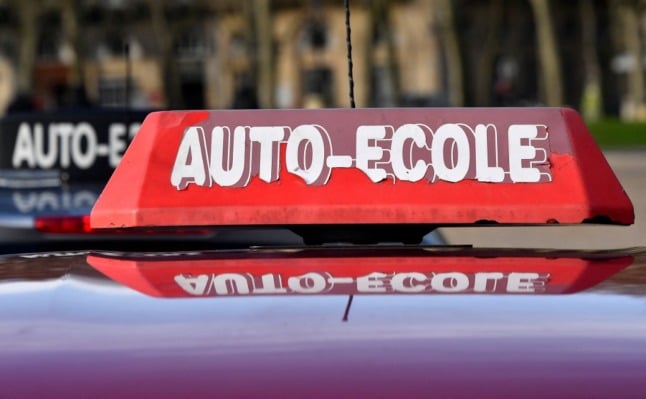 Close-up of an 'auto-ecole' sign on top of a vehicle used by a driving school in France