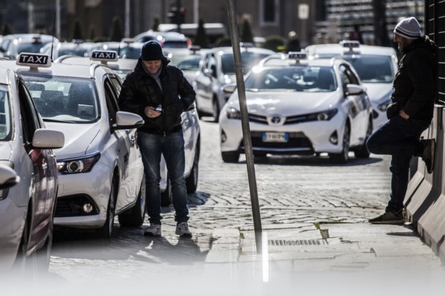 Taxi drivers wait for customers at a taxi rank on Piazza Venezia in downtown Rome.