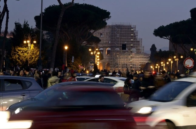 Cars drive past Rome's Piazza Venezia.