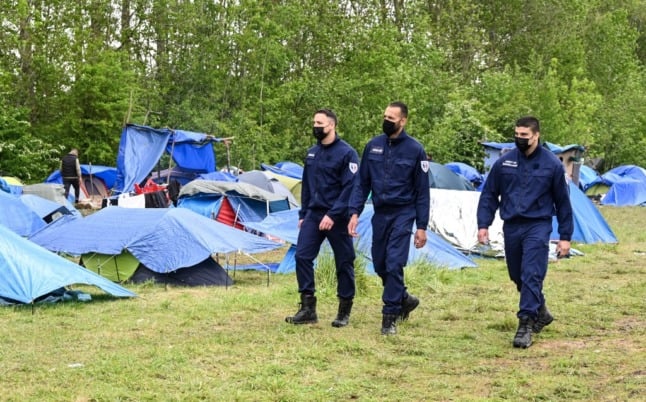 French police patrol through migrant camp near Calais. These camps are being systematically cleared. 