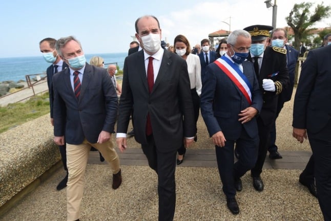 Prime Minister Jean Castex, centre, walks with other officials 