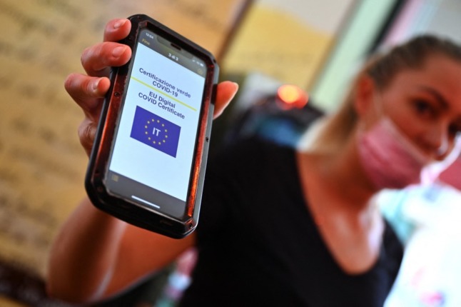 A customer shows her Green Pass on a mobile phone in a central Rome bar