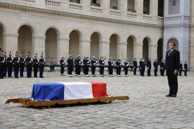 President Macron stands to attention next to the coffin of late French resistance leader, Hubert Germain