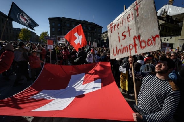 A protester holds up a banner reading in German 'freedom is unvaccinable' during a rally in opposition with the current measures to tackle the spread of the coronavirus, Covid-19 health pass and vaccination, in Bern