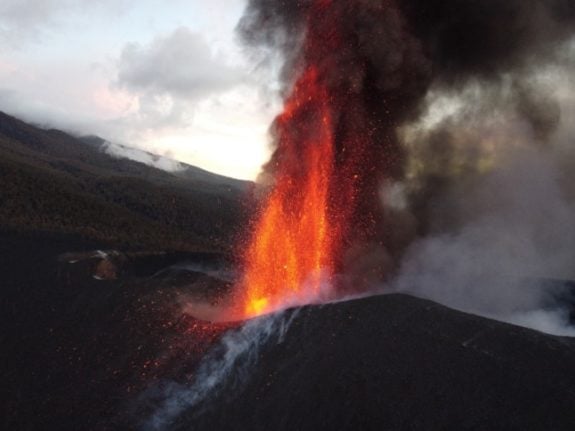 This photograph shows the Cumbre Vieja volcano spewing lava, ash and smoke