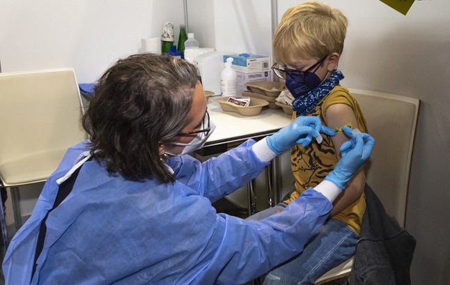 A boy receives his first shot of the corona vaccine in Vienna