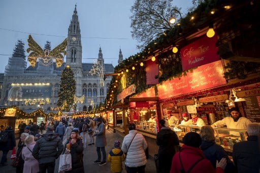Visitors wait for hot drinks at the traditional annual Christmas Market outside of Vienna's city hall 