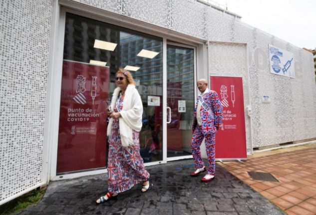 Union Jack-themed British tourists walk past the mobile Covid-19 vacination centre at Benidorm tourist office on November 18th,