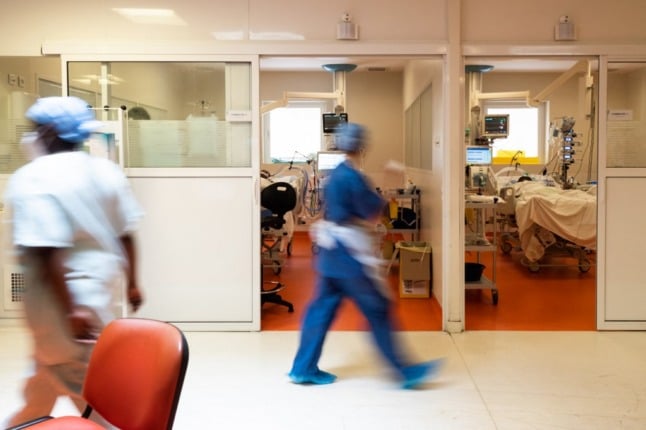 Medical staff walk past a room of a Covid-19 patient at the intensive care unit of the Centre hospitalier universitaire in Pointe-a-Pitre, Guadeloupe