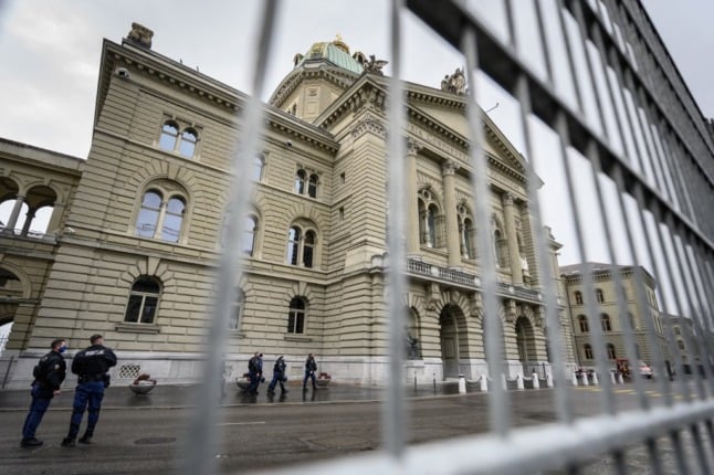 Policemen are seen behind fences closing the House of Swiss Parliament in Bern