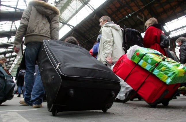 Passengers carry luggage while travelling during the Christmas period.