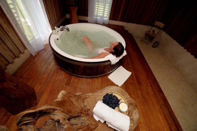 A woman relaxes in a jacuzzi at a spa.