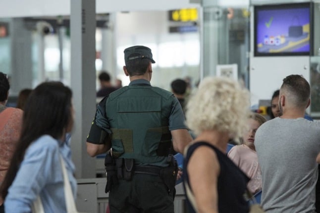 A Spanish civil guard helps with security checks at Barcelona's El Prat airport