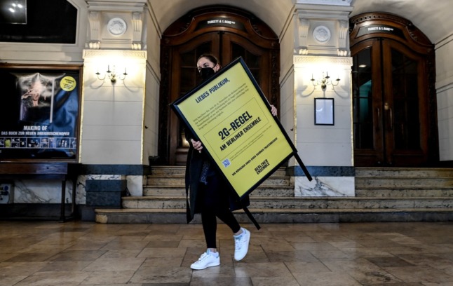 An employer with the Berliner Ensemble carries a sign that says entry is only allowed for people with proof of vaccination or recovery from Covid.