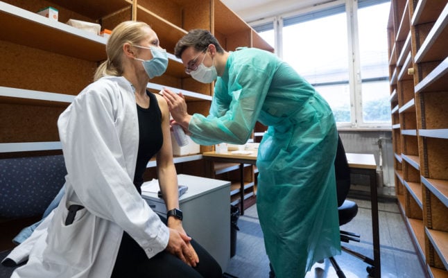 A doctor receives a Covid jab from a medical student in Tübingen. Covid vaccination could soon become compulsory for medical and care staff in Germany. 