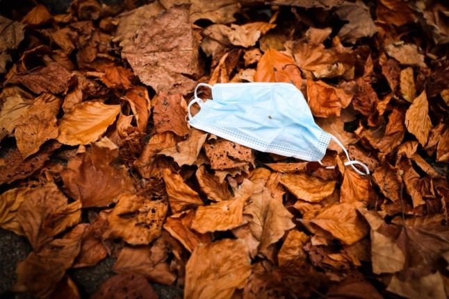 A face mask lies in autumn leaves in Hamburg. 