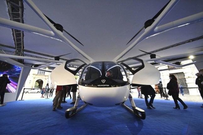 People look at a VoloCity drone, the air taxi created by the German company Volocopter, displayed at the Piazza San Silvestro in Rome, on November 4, 2021. 