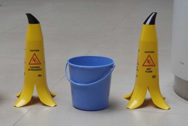 Two 'caution wet floor' signs in the shape of banana peels.