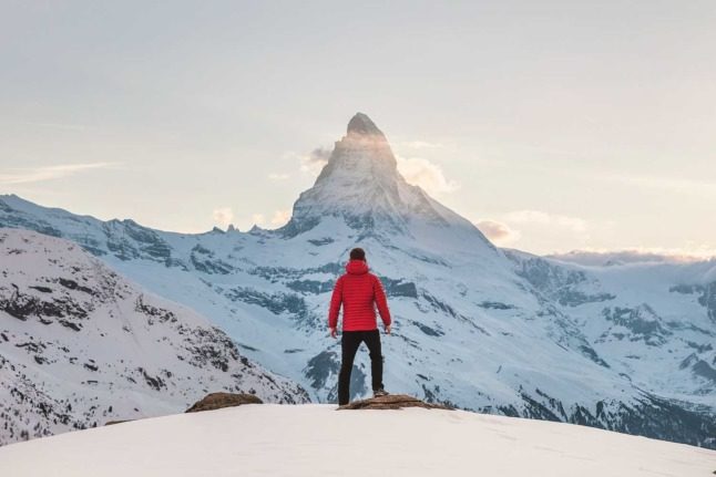 A man stands in front of the Matterhorn in the Swiss region of Zermatt