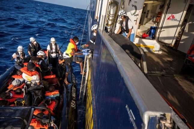 Crew members of civil sea rescue ship Sea-Watch 4 help migrants to board the rescue ship on August 29, 2020. 