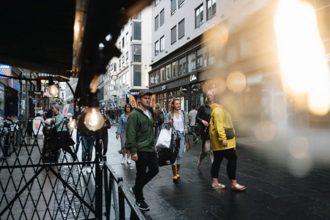 Crowds walking down a busy Oslo street. 