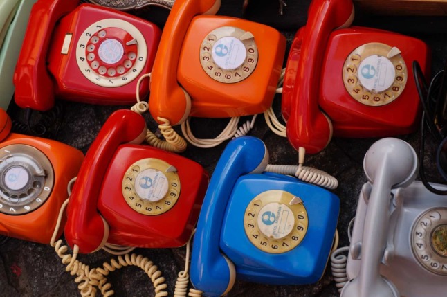 Several rotary phones sitting next to each other