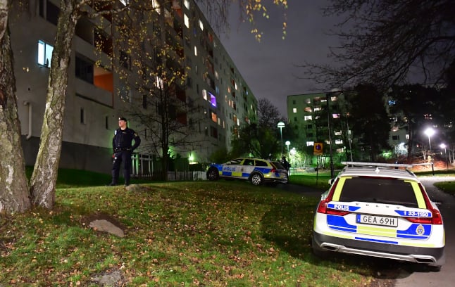 a police officer outside the apartment block in hässelby, stockholm, sweden