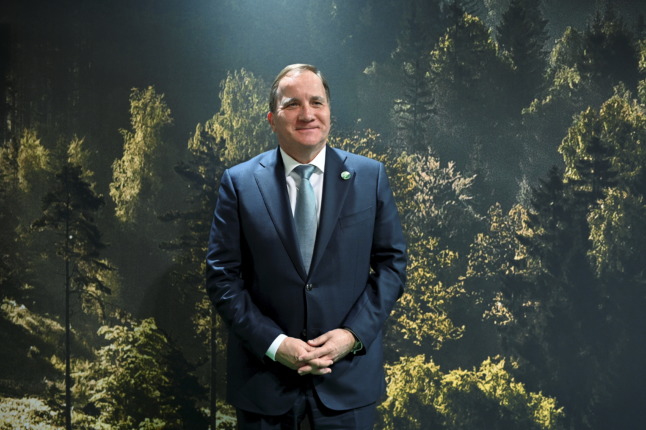 sweden's outgoing prime minister in front of a backdrop of a forest