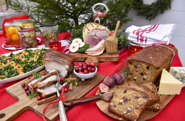 a julbord christmas buffet featuring herring, christmas ham, bread and cheese