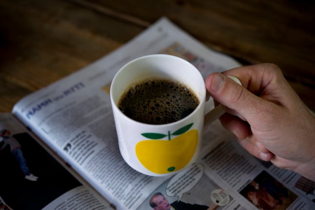 a cup of coffee on a newspaper