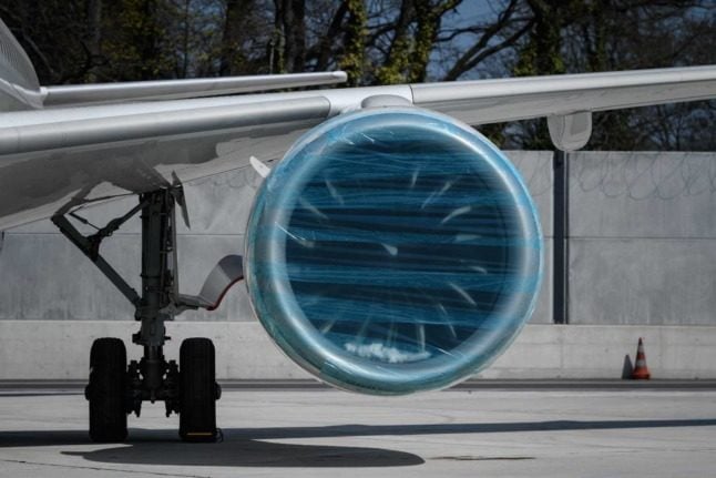 An engine covered in plastic wrap on the tarmac at Geneva Airport