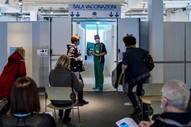 People wait to be vaccinated at a hub in Milan.