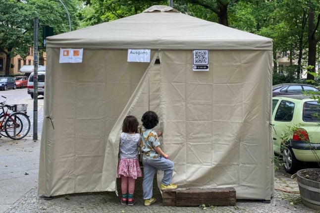 Children peek into a Covid testing tent in Berlin