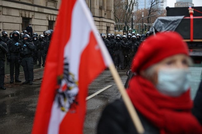 A protestor holds the Austrian flag