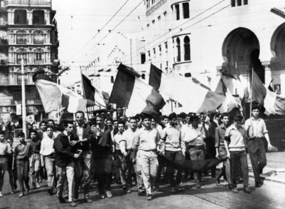 Young people wave French flags in Algiers, 1958. The government is set to declassify documents that will likely shed light on atrocities committed by France during the Algerian war of independence.