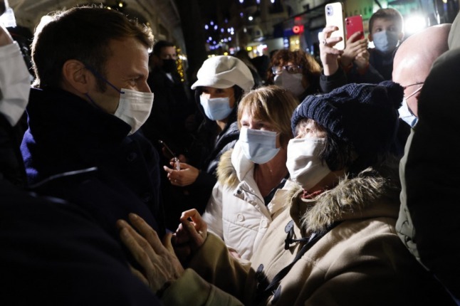 French President Emmanuel Macron, in a facemask, greets people in a crowd in the town of Vichy, central France