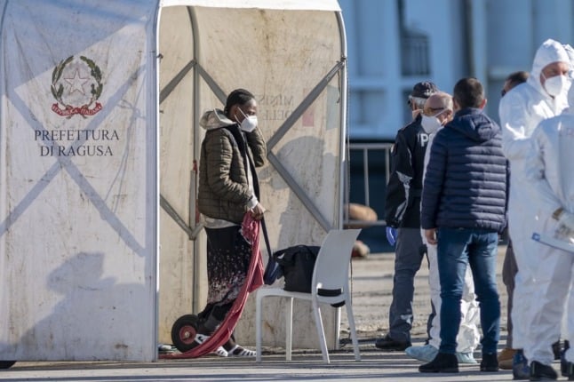 Migrants wait for assistances by Italian authorities in the port of Pozzallo, southern Sicily.