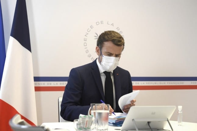 Macron sits at a desk