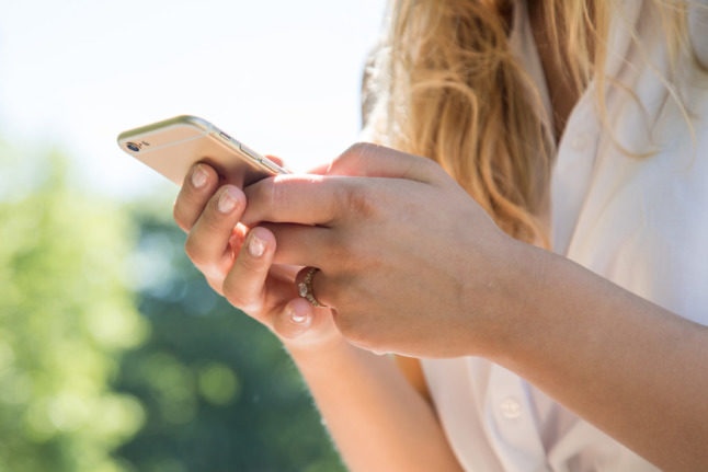 A woman sends a message on her mobile phone