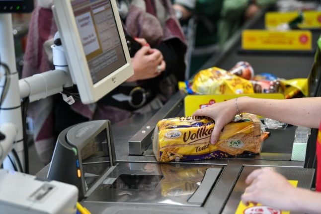 A person buying groceries at a Berlin supermarket. 