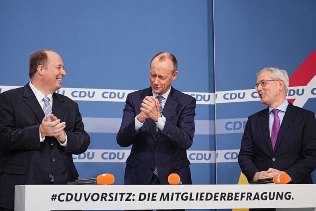 Friedrich Merz (middle) is congratulated by Helge Braun (left) and Norbert Röttgen on winning the CDU leadership vote.