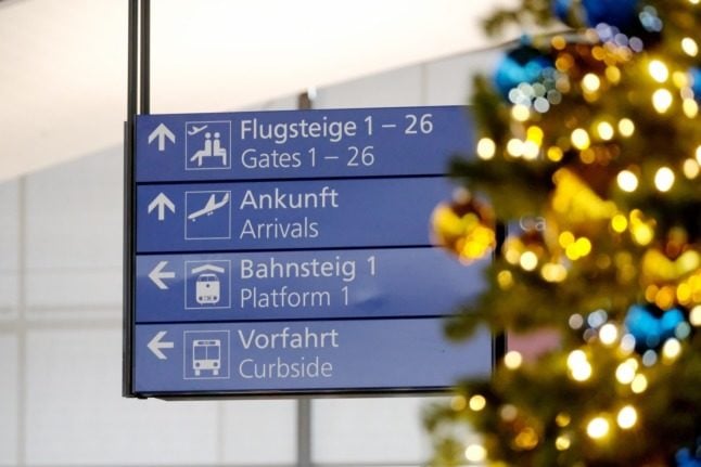 A sign at Leipzig airport next to a Christmas tree. 