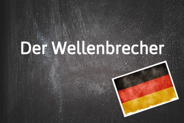 A blackboard shows the German word 'der Wellenbrecher.