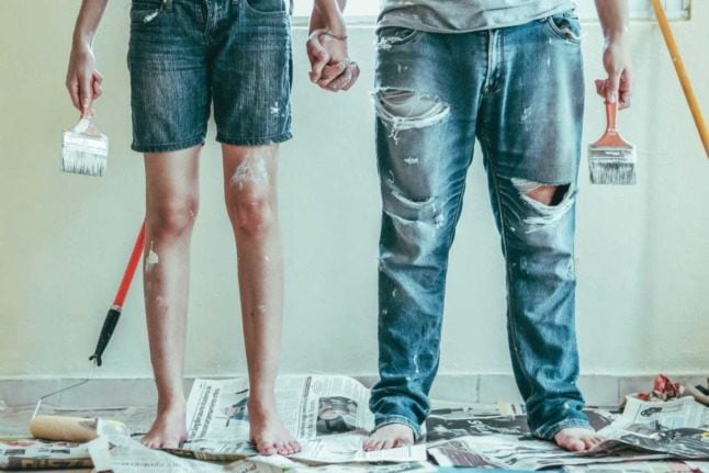 A couple covered in paint after renovating a house