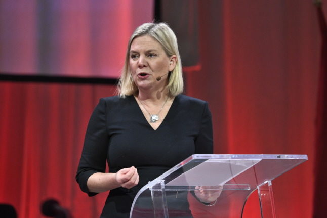 magdalena andersson holding a speech in front of a red curtain