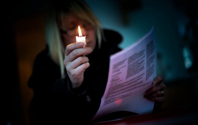 a woman reading her energy bill by candlelight