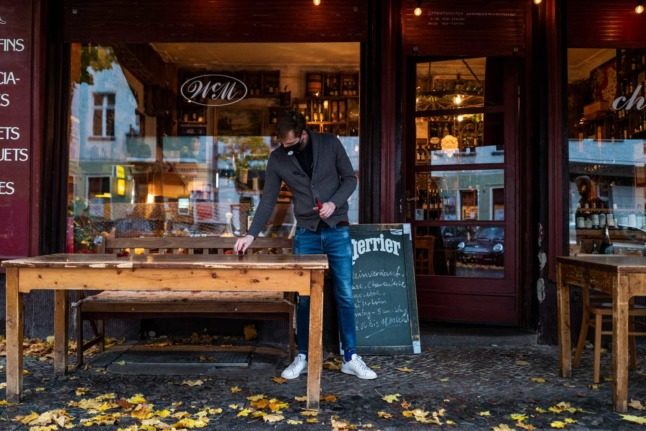 A waiter sets a table at a bar/restaurant in Berlin