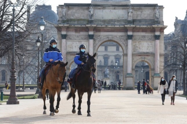 Masked Paris police officers patrol on horseback. 