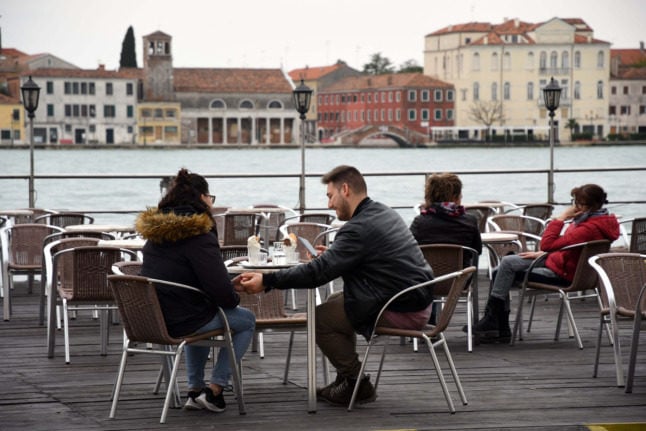People have a coffee on a terrace bar at the Zattere in downtown Venice.